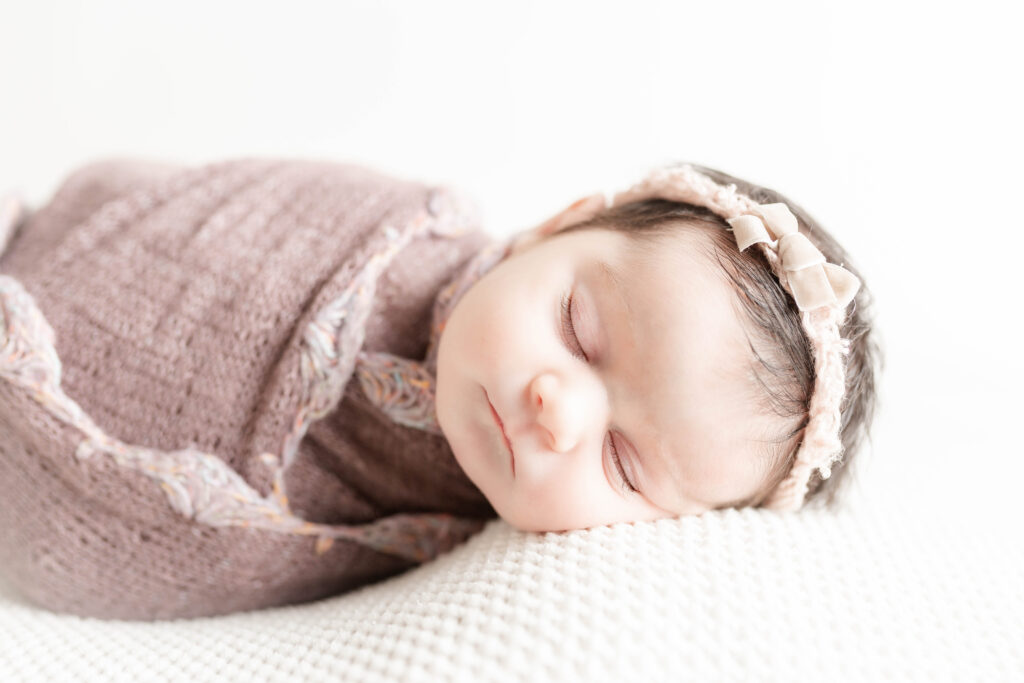 South Jersey Newborn Photographer baby girl in purple wrap with flower headband